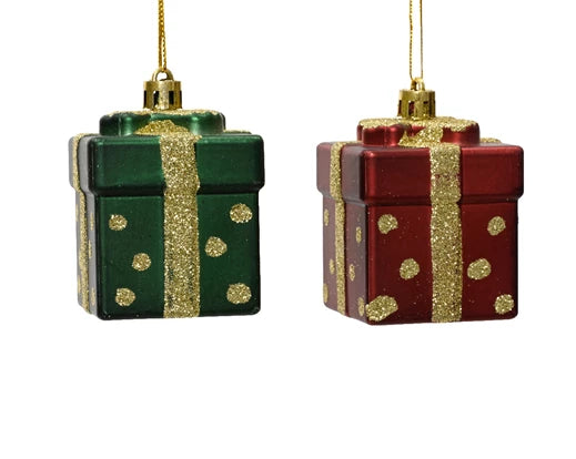 Two Christmas ornaments shaped like gift boxes with gold polka dots on a white background.