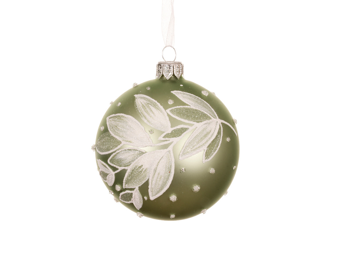 Green Christmas ornament with white floral design on a white background