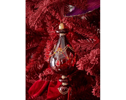 Oxblood glass Christmas ornament hanging on red tree, embellished with glitter, beads, and diamond detailing
