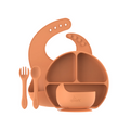 Orange silicone bib, bowl, spoon, and fork set on a white background
