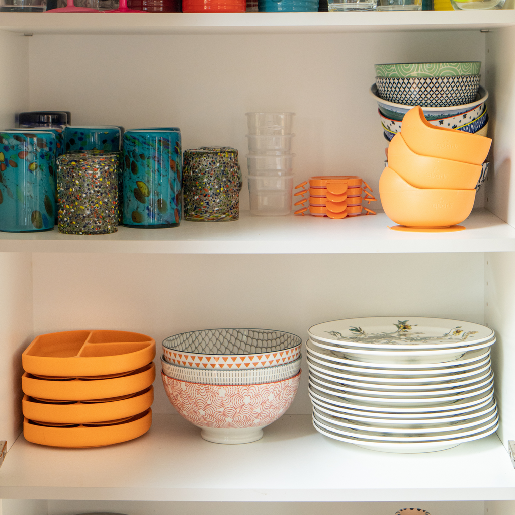 Shelves with colorful kitchenware including bowls, plates, and cups.