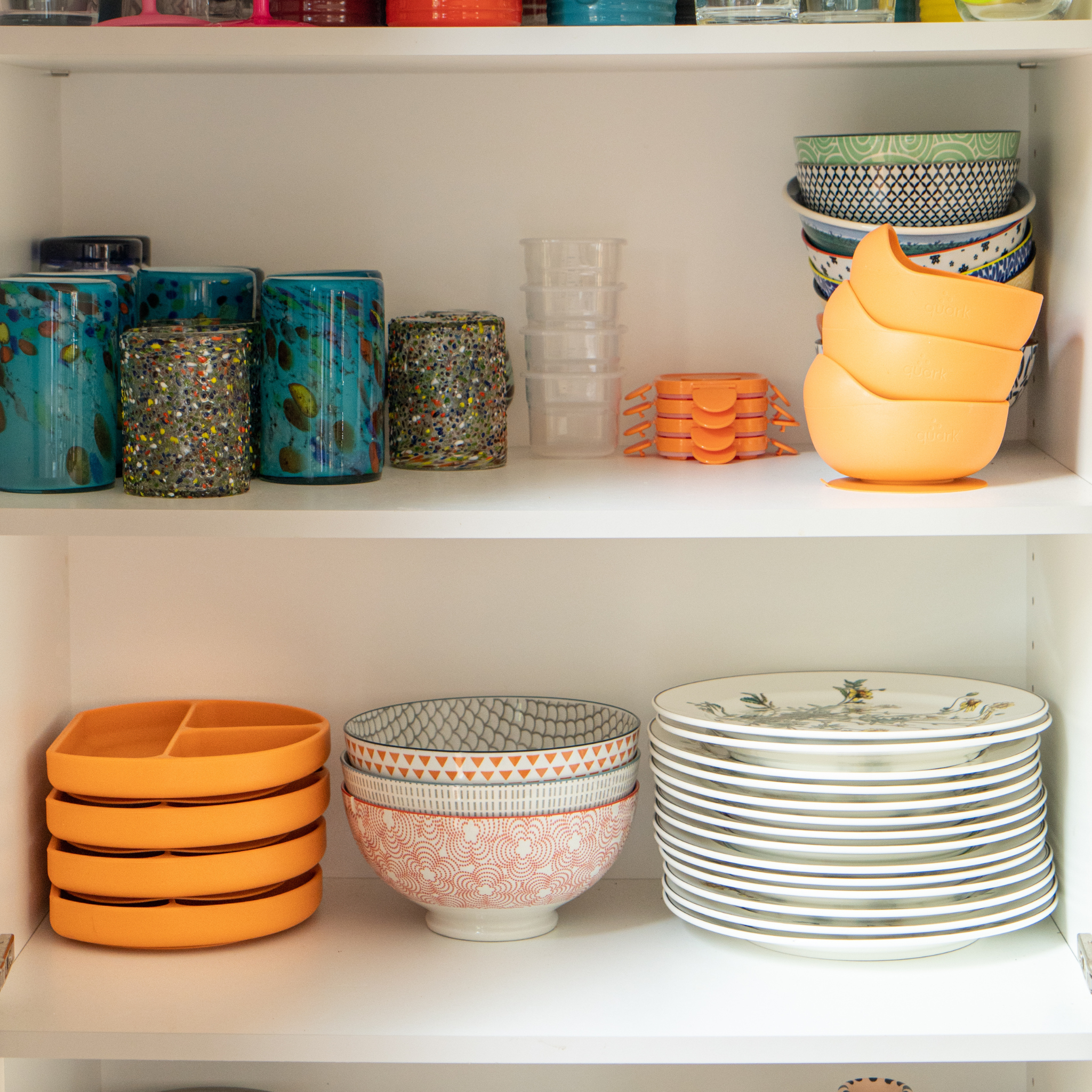 Shelves with colorful kitchenware including bowls, plates, and cups.
