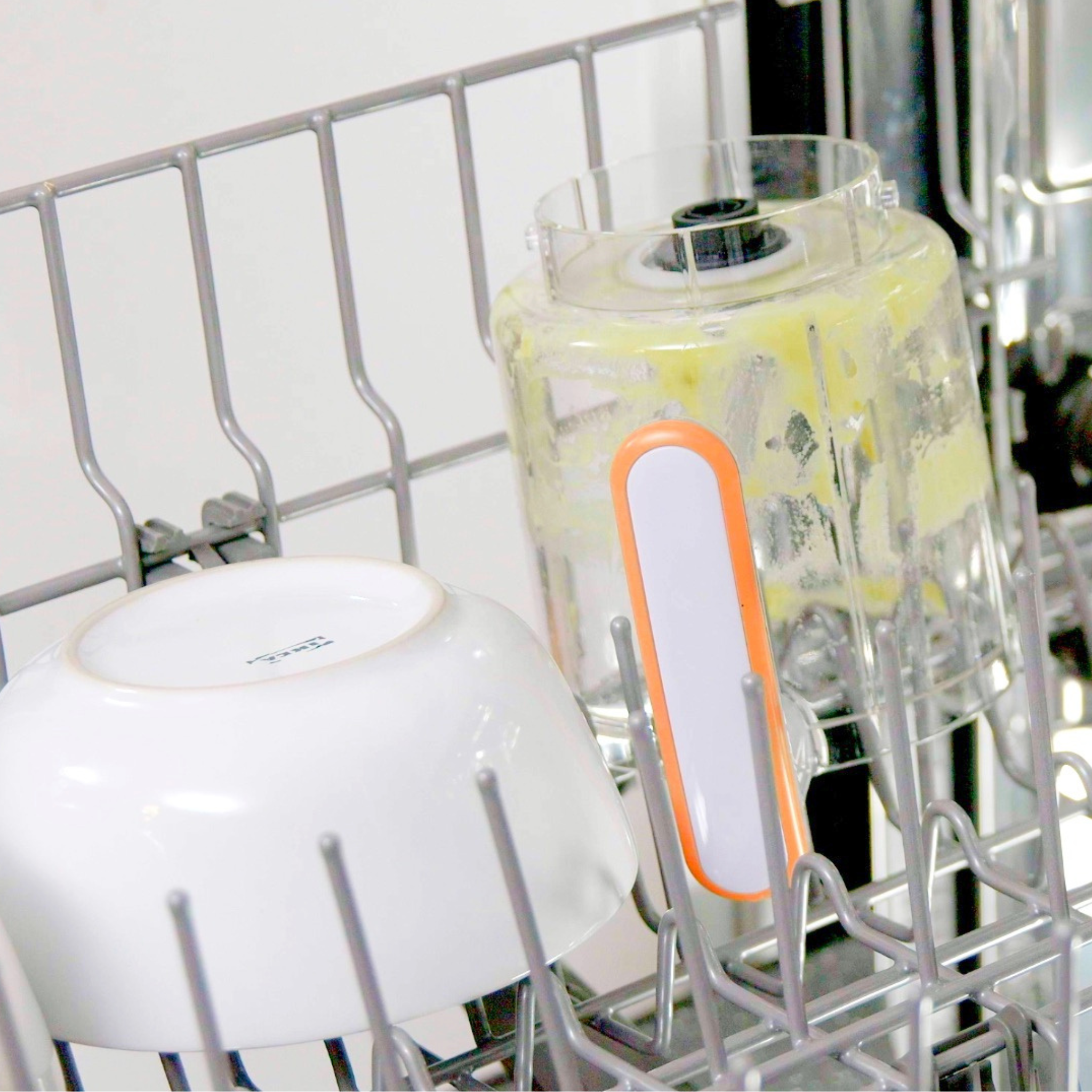 Dishwasher rack with a blender and a white plate inside