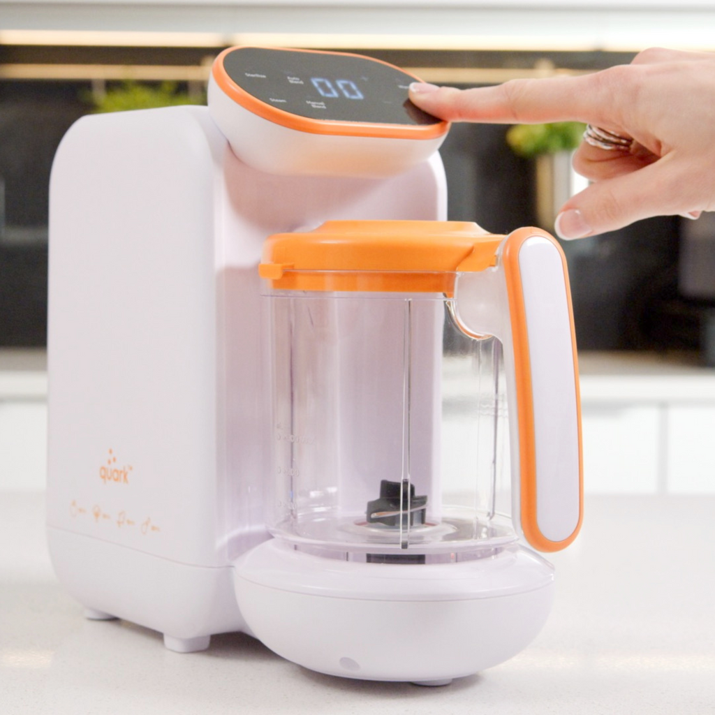 White and orange baby bottle sterilizer with a hand pressing a button.