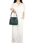Person holding a green handbag against a white background
