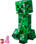 Green Minecraft creeper figure made of interlocking bricks with a small pink pig and TNT block on a white background.