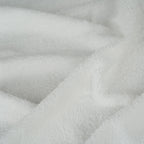 A close-up of soft white plush fabric with a textured, terry-like surface and gentle folds.