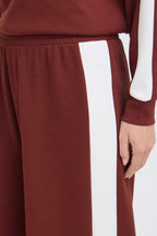 Brown sweatshirt and pants with a white stripe on a white background