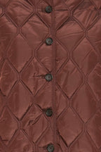 Close-up of a FRAGATE Outerwear in Rum Raisin/Red, featuring a diamond quilting pattern and a vertical row of dark buttons down the center front.