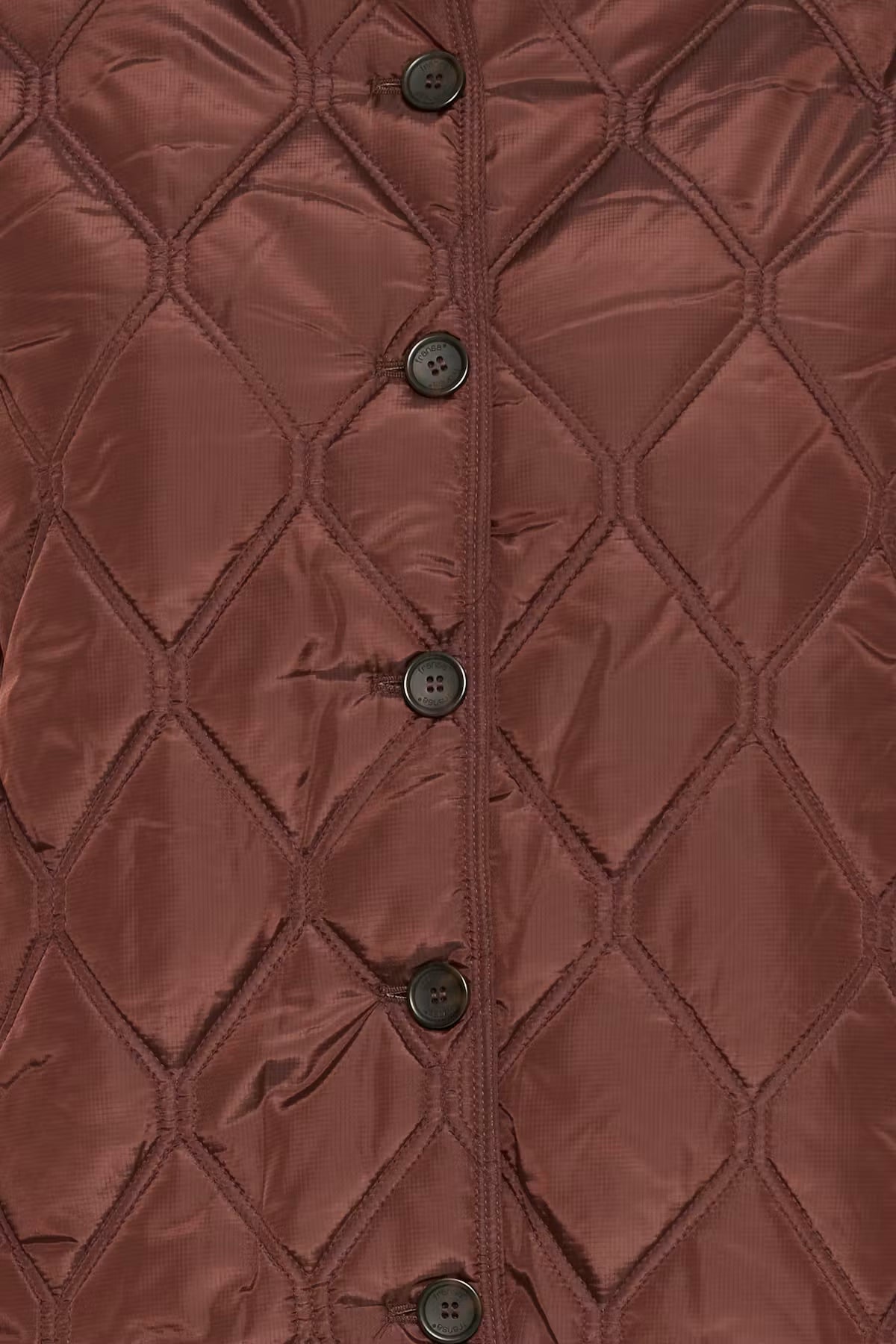 Close-up of a FRAGATE Outerwear in Rum Raisin/Red, featuring a diamond quilting pattern and a vertical row of dark buttons down the center front.