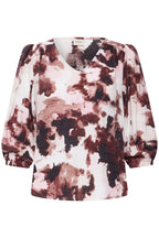 A Watercolour Bloom Rum Raisin / Red women's blouse with a V-neckline and three-quarter puff sleeves, on white base.