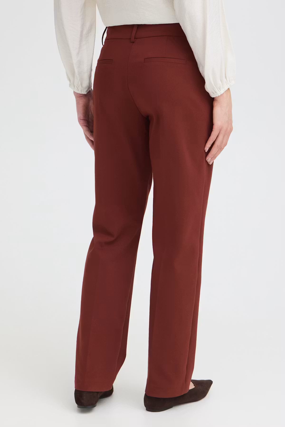 
Rum Raisin / Red straight-leg trousers shown on a model from the back, paired with a white blouse and dark brown flats against a clean white background.