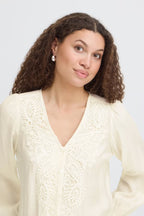Woman wearing a Whisper White cable knit sweater against a white background