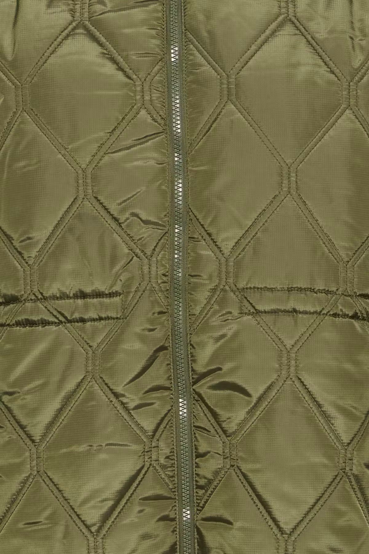 Close-up of a quilted jacket FRAGATE Outerwear in Grape Leaf/Green with a central zipper and stitched diamond pattern.