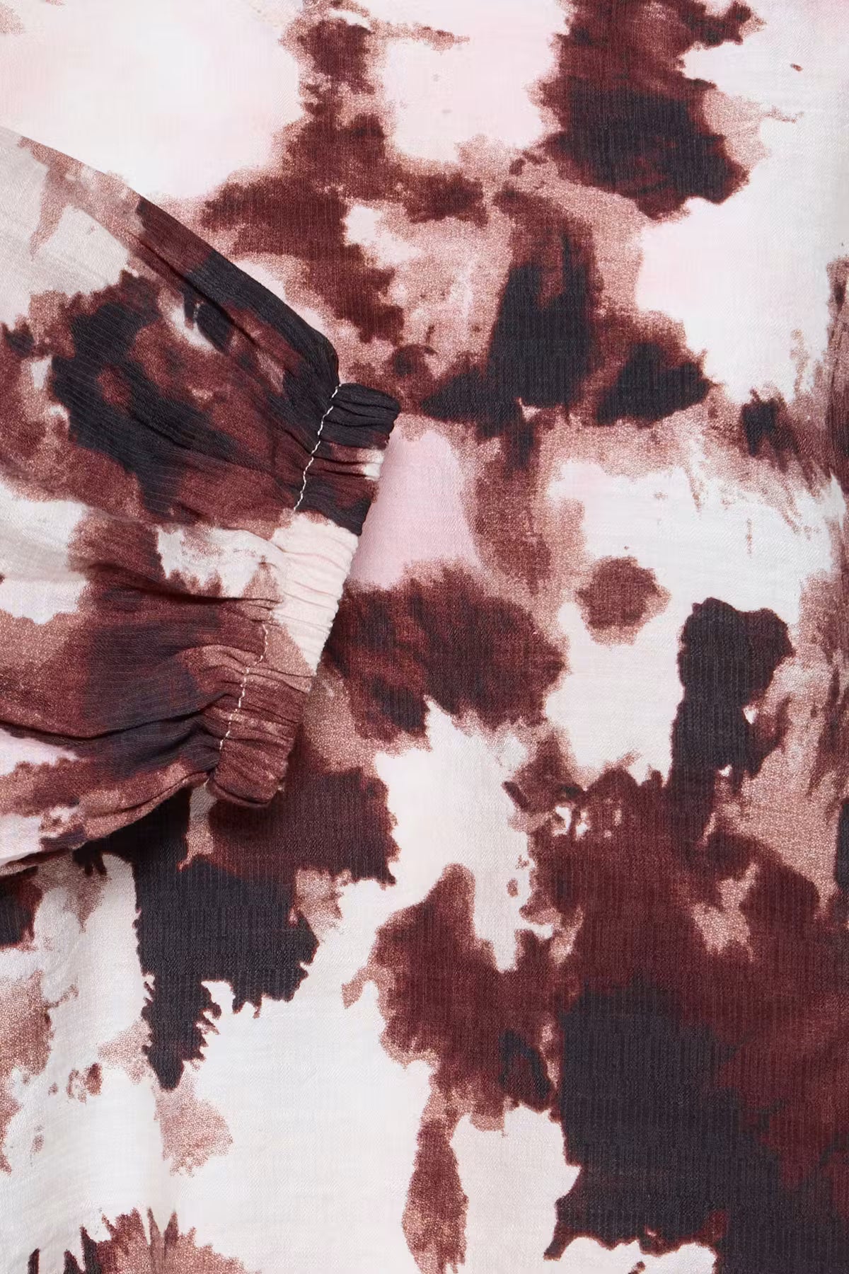 A close-up of a fabric product featuring an abstract Watercolour Bloom Rum Raisin / Red 