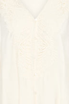 Close-up of a Whisper White lace and satin button-front garment, showing intricate floral lace embroidery and a V-neckline.