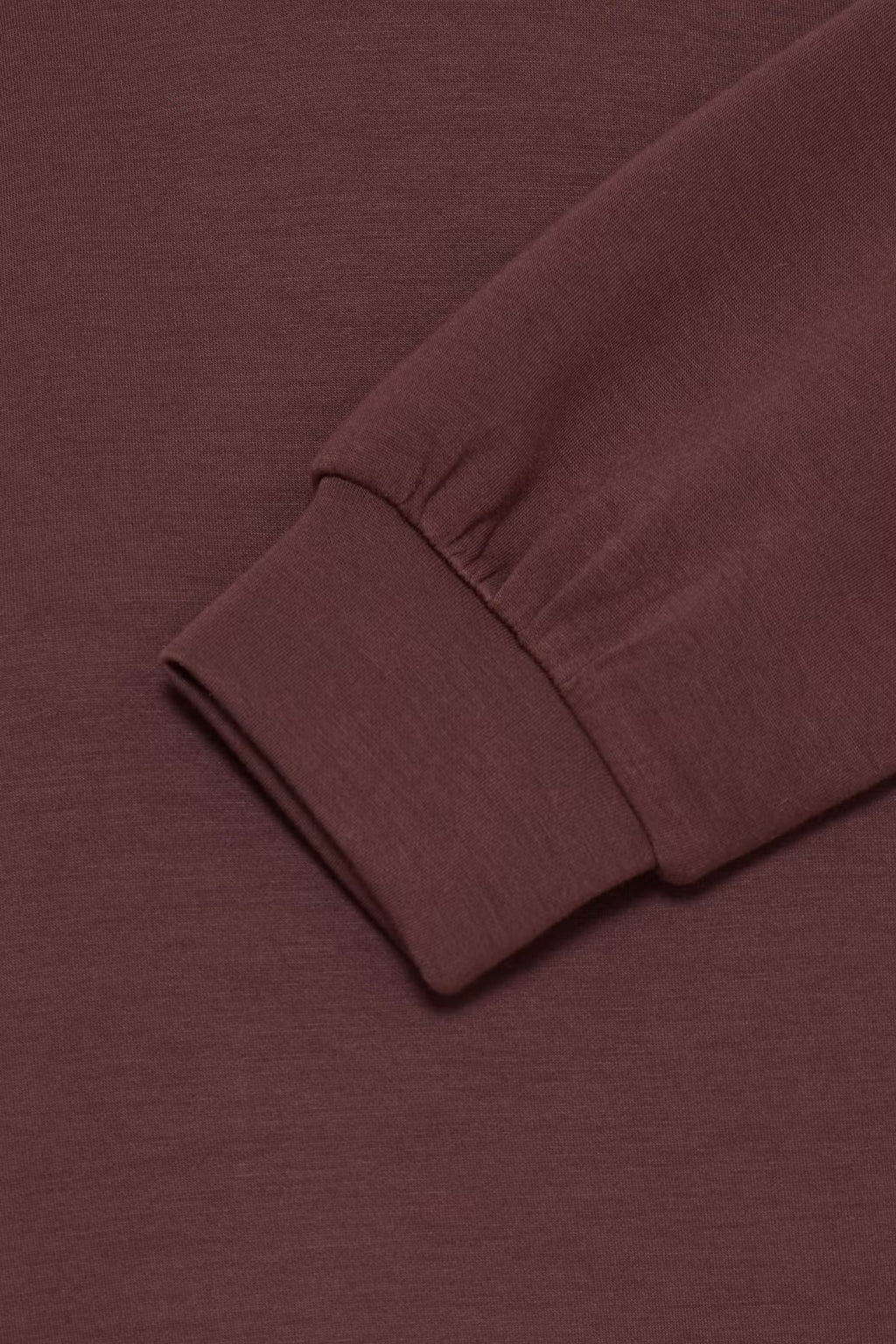 Close-up of a ribbed long-sleeve cuff in a FRAURORA PU 7 Sweatshirt in Rum Raisin/Red , showing the texture and fold of the sleeve against a matching background.