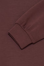 Close-up of a ribbed long-sleeve cuff in a FRAURORA PU 7 Sweatshirt in Rum Raisin/Red , showing the texture and fold of the sleeve against a matching background.