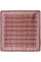 A square Rum Raisin  scarf with a geometric pattern, featuring a rust red background with white chevron and herringbone motifs, displayed flat against a white background.