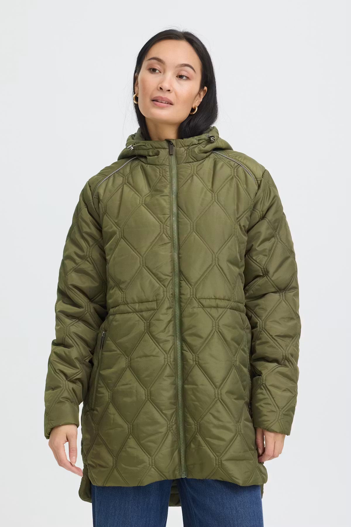 A woman wearing FRAGATE Outerwear in Grape Leaf/Green with a diamond-stitched pattern, shown against a plain light gray studio background.