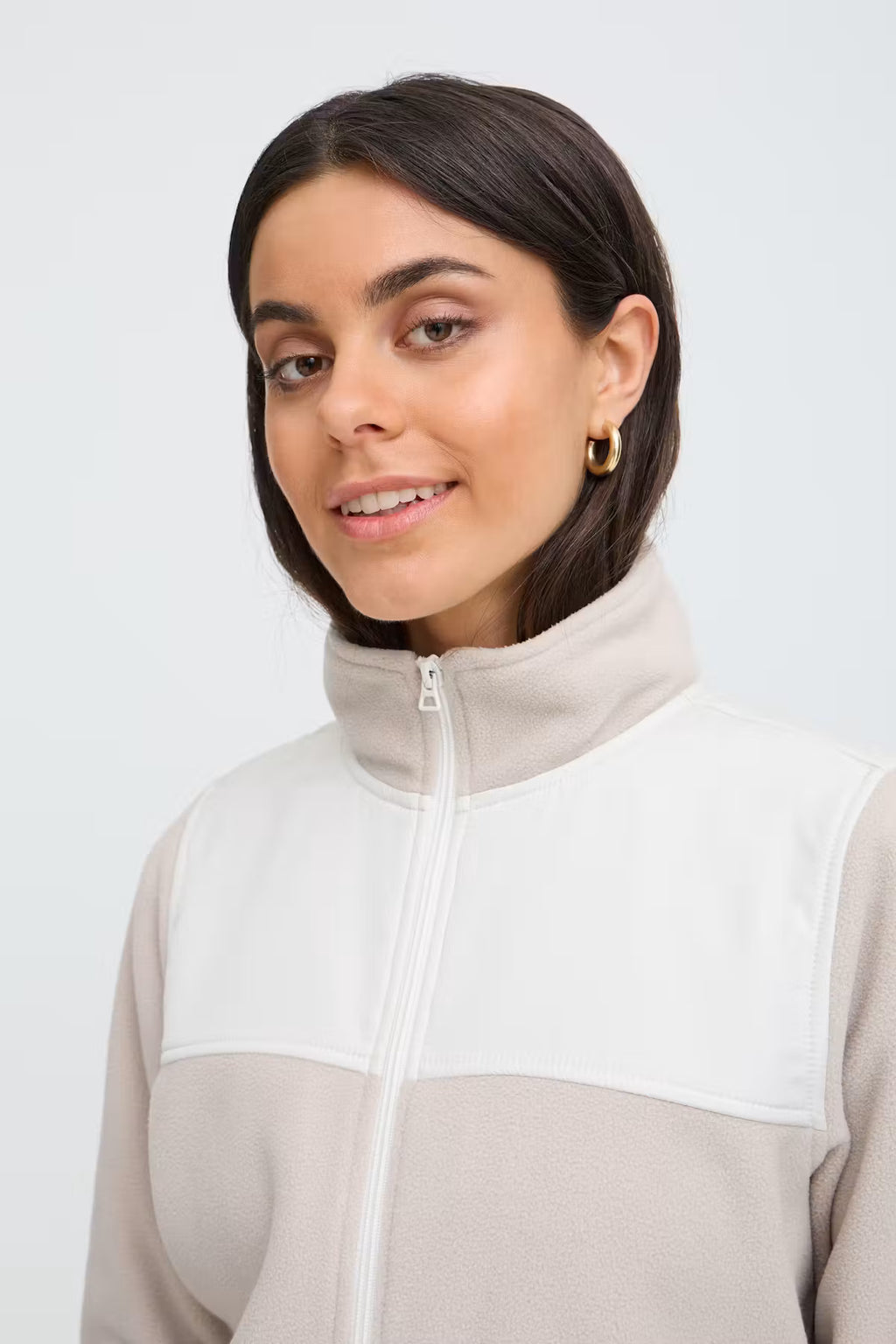 A woman wearing a FRFLEA Outerwear in String/Nature with a beige lower section, a white chest panel, and a light beige collar, shown against a plain light gray background.