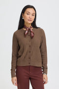 A woman modeling a brown ribbed button-front cardigan sweater with a Rum Raisin neck scarf, paired with burgundy trousers, against a light gray studio background.