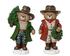 Two teddy bear figurines dressed in festive clothing with wreaths on a white background