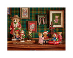 Collection of teddy bears in festive attire against a plaid wall with framed pictures.
