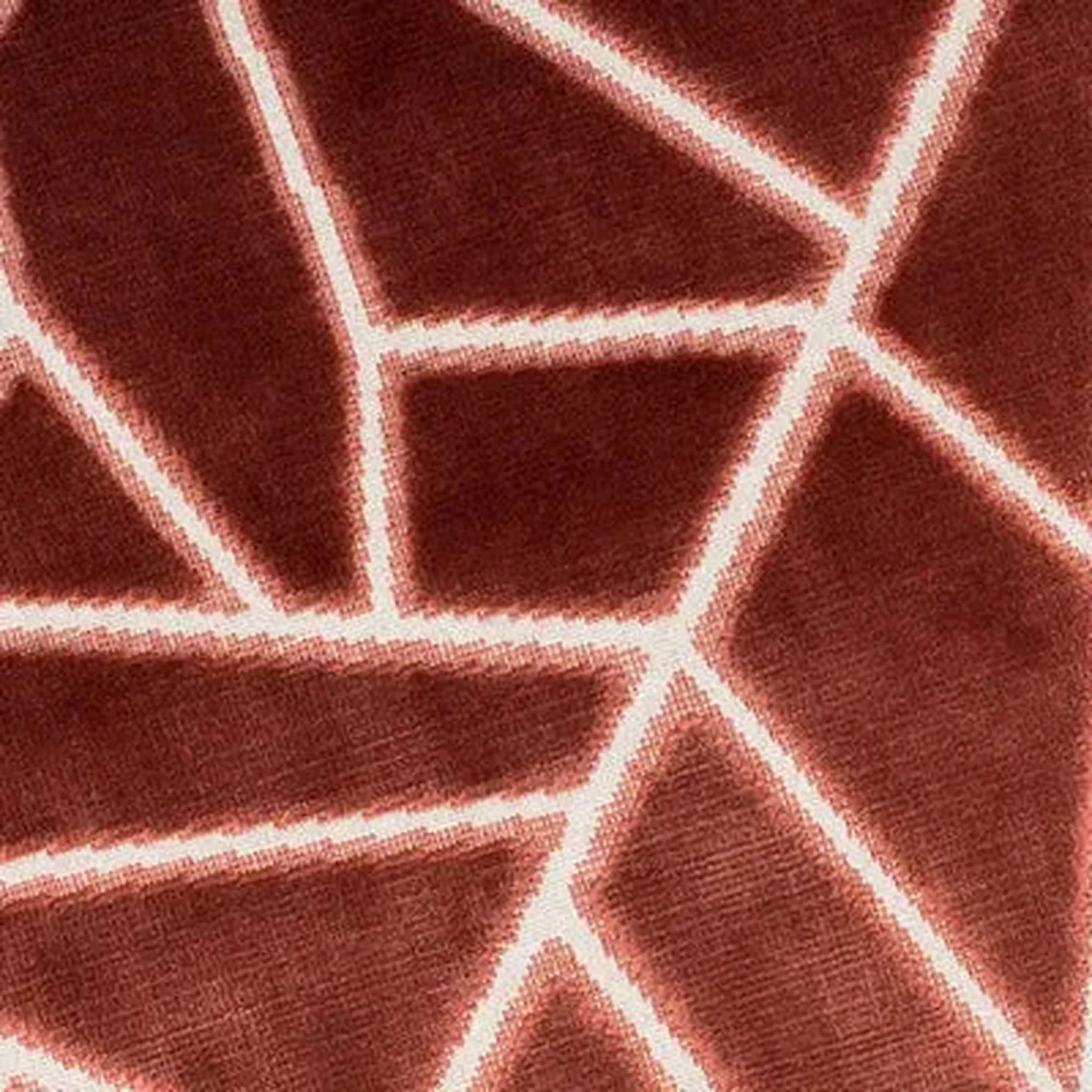 A close-up of Veda Cushion in Antique Rose textured fabric with a white geometric line pattern.