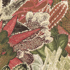 Close-up of a Merida Cushion in Green  floral pattern with red, green, and white colors.
