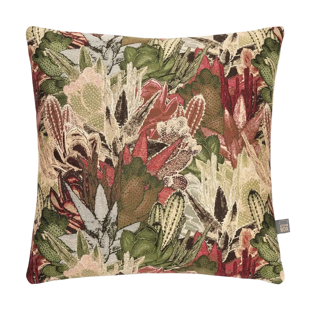 A square decorative Merida Cushion in Green featuring a dense, detailed botanical and cactus pattern in shades of green, red, beige, and brown, shown against a plain white background.