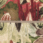 Close-up of a textured fabric with floral patterns in red, green, and beige.