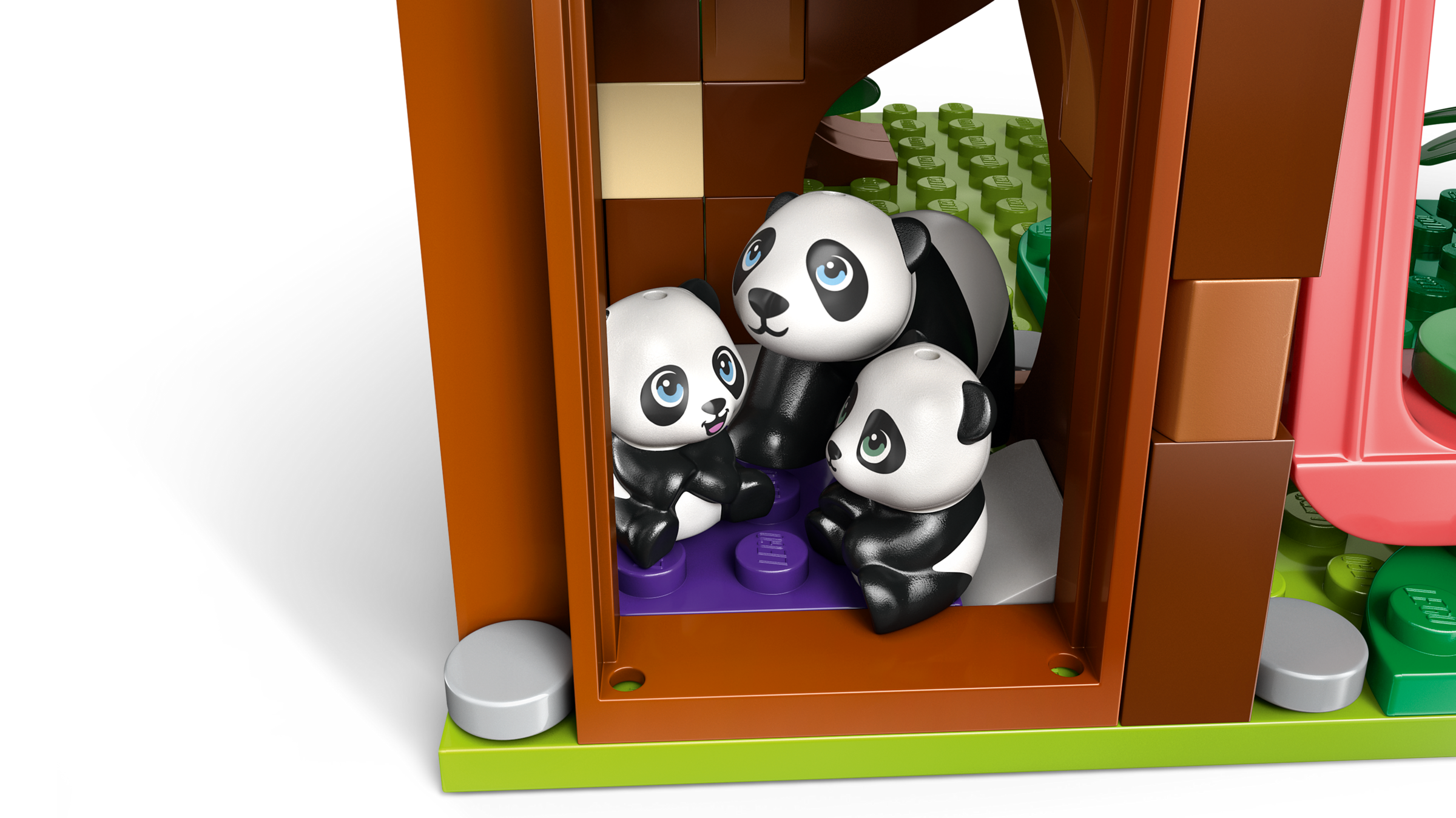 LEGO panda family inside a wooden cabin on a white background