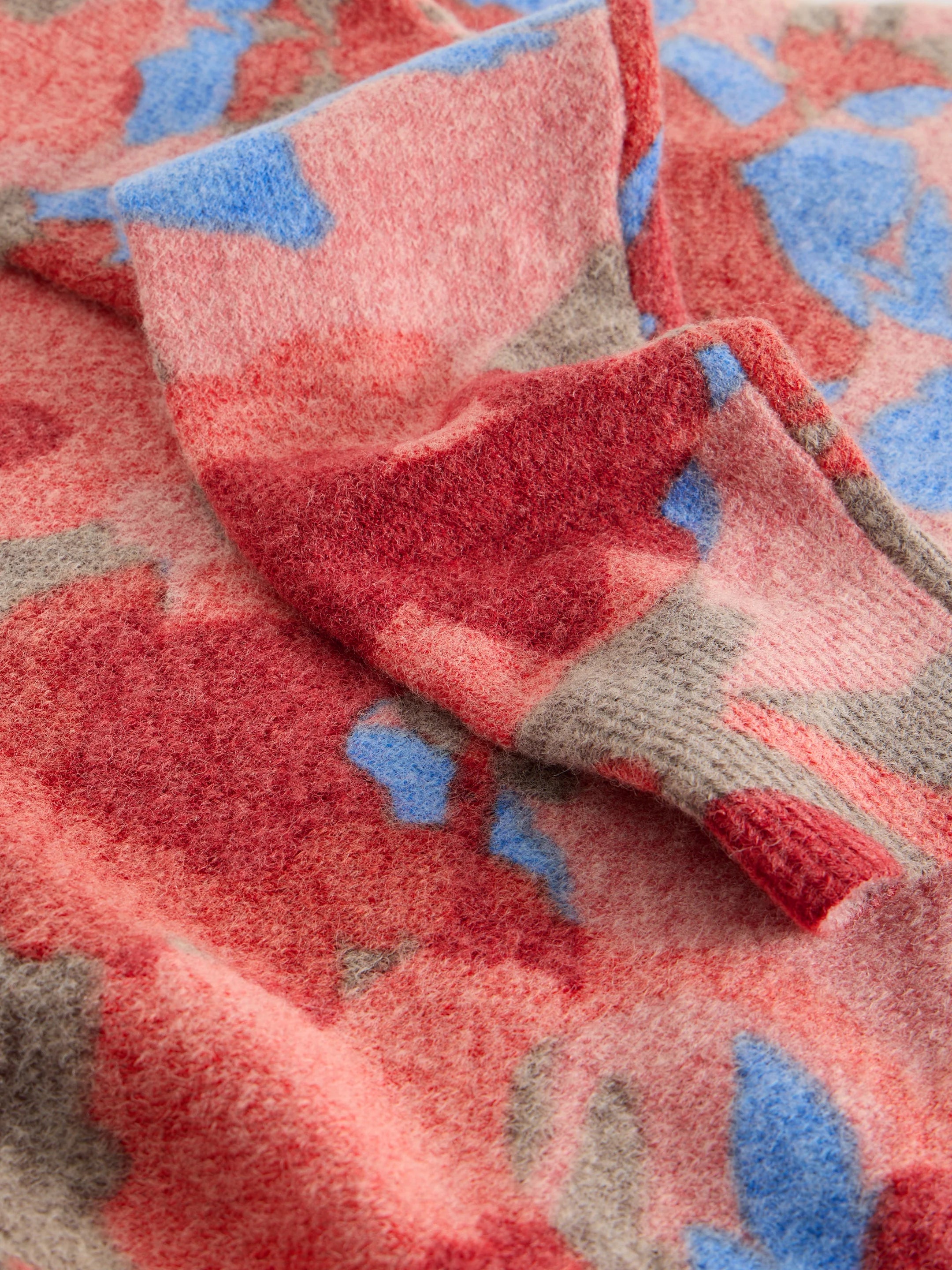 Close-up of a textured fabric with red, blue, and gray colors.