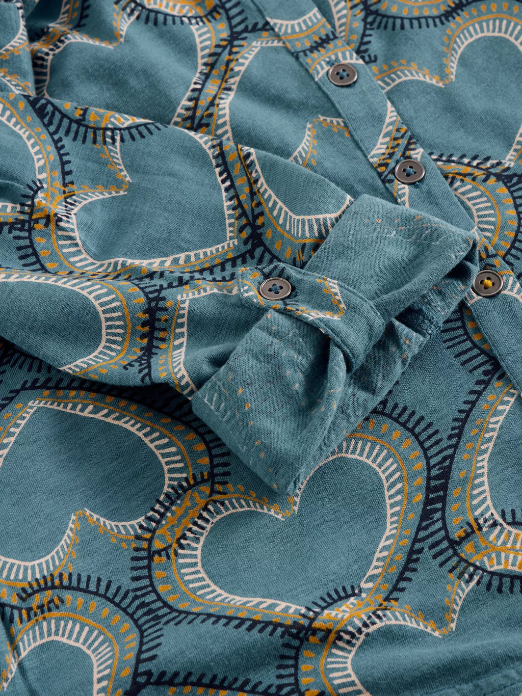Folded blue fabric with decorative patterns on a matching background
