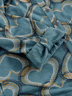 Folded blue fabric with decorative patterns on a matching background