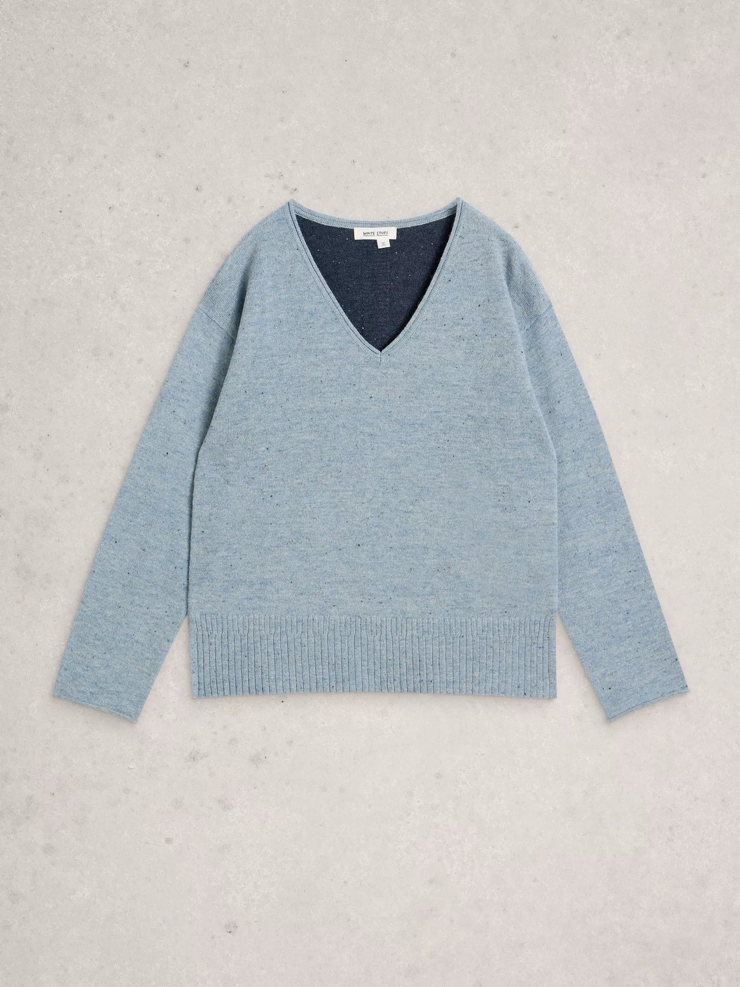 Light blue sweater with a dark blue V-neck on a light gray background