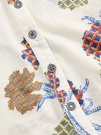 Close-up of a fabric with colorful geometric patterns and buttons on a white background