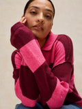 Person wearing a pink and purple striped sweater against a neutral background