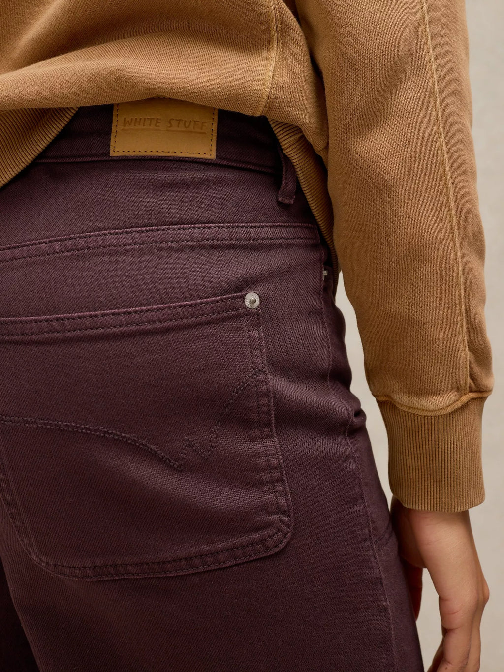 Person wearing a brown jacket and TIA brown WIDE LEG CROP JEAN with a visible brand label.