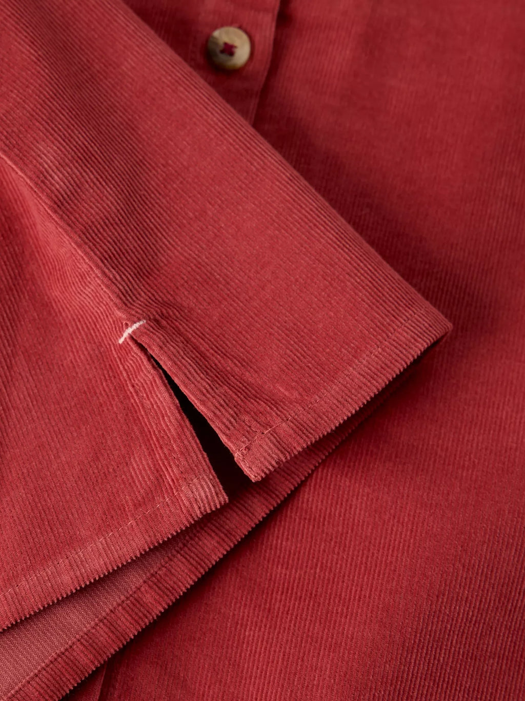 Close-up of LANA dusty pink BABY CORD TOP showing the textured fabric, button, and folded cuff detail.