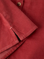 Close-up of LANA dusty pink BABY CORD TOP showing the textured fabric, button, and folded cuff detail.