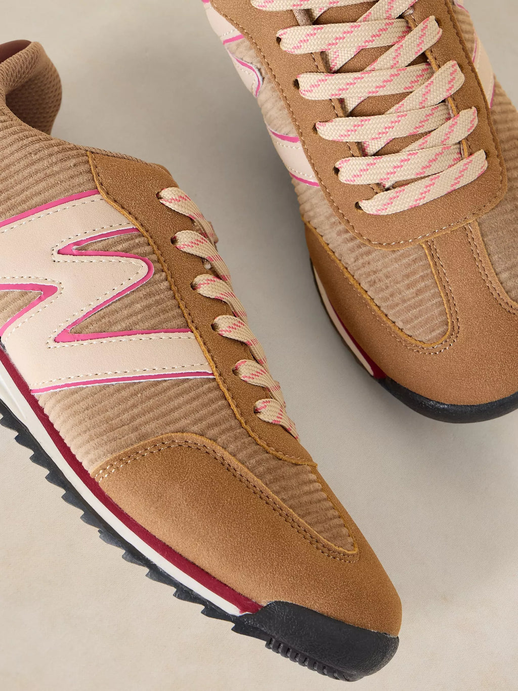 A pair of A Lucy Trainer sneaker in Natural multi  in tan suede and textured knit, featuring cream overlays with pink trim, pink-and-beige laces, and a black and red sole.