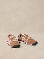 A pair of A Lucy Trainer sneaker in Natural multi  in tan suede and mesh with light pink accents, shown on a neutral beige background.