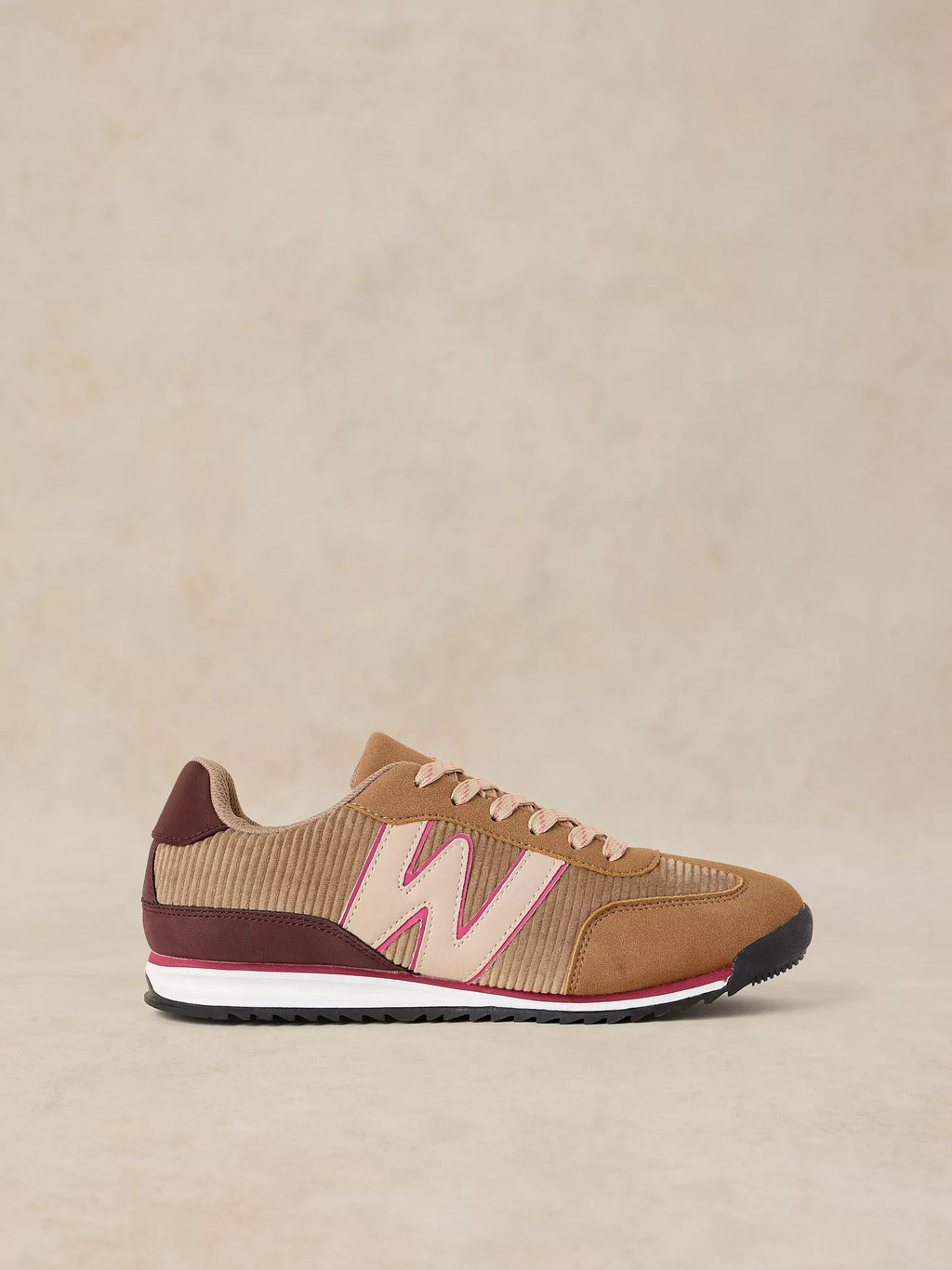 A Lucy Trainer sneaker in Natural multi and corduroy with a large light pink 'W' logo, burgundy heel tab, and a white midsole with a thin pink stripe, set against a neutral beige background.
