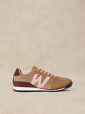 A Lucy Trainer sneaker in Natural multi and corduroy with a large light pink 'W' logo, burgundy heel tab, and a white midsole with a thin pink stripe, set against a neutral beige background.