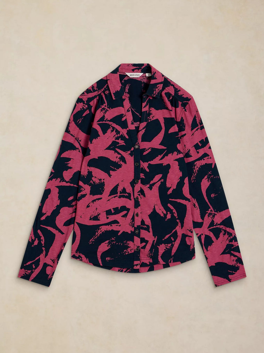 Pink and black patterned shirt on a beige background