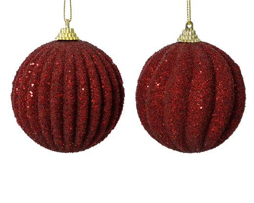 Two red glittery Christmas ball ornaments on a white background