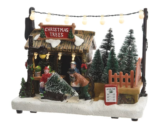 Decorative Christmas scene with a tree stand and people around it, featuring a 'Christmas Trees' sign