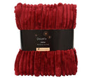 Red textured throw blanket with a black label on a white background